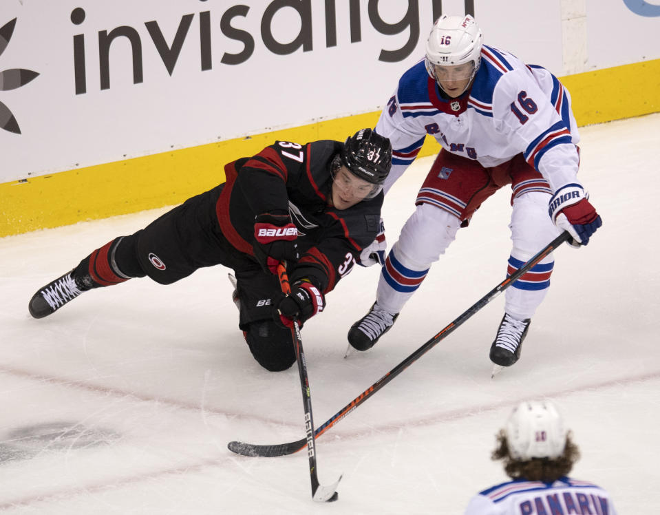 Carolina Hurricanes right wing Andrei Svechnikov (37) and New York Rangers center Ryan Strome (16) battle for the puck during the first period in the NHL hockey Stanley Cup playoffs in Toronto, Saturday, Aug. 1, 2020. (Frank Gunn/The Canadian Press via AP)