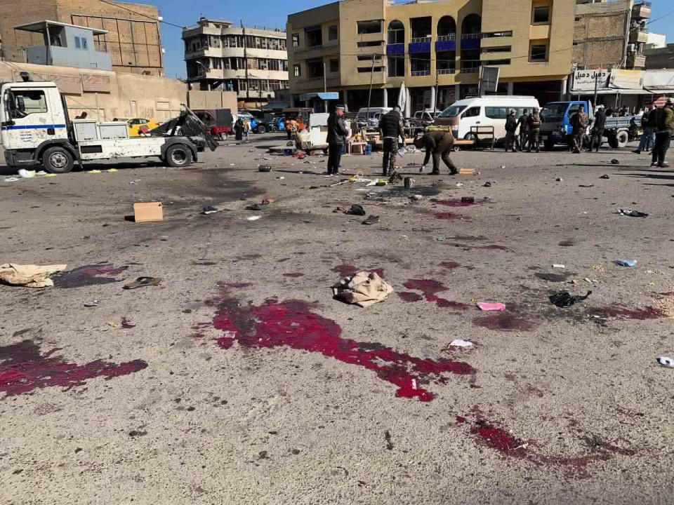 Security forces work at the site of a deadly bomb attack in a market selling used clothes, Iraq, Thursday, Jan. 21, 2021. Twin suicide bombings hit Iraq's capital Thursday killing and wounding civilians, police and state TV said.