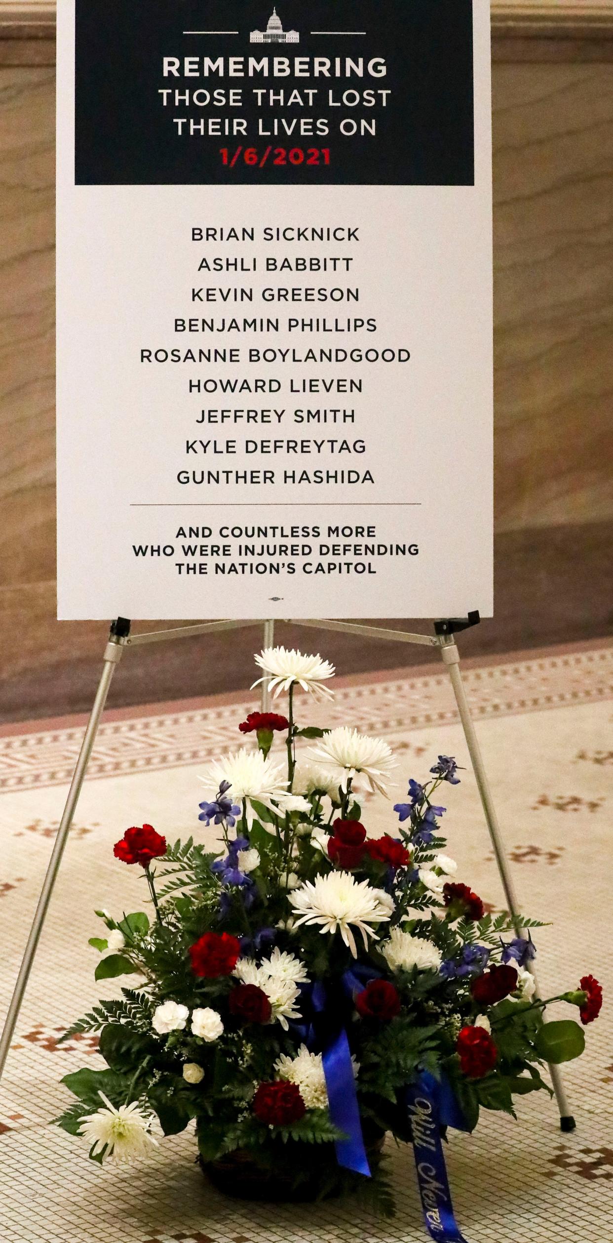 A poster is displayed in Milwaukee City Hall Rotunda commemorates those who died on the Jan. 6  insurrection and in the weeks and months after at the U.S. Capitol in Washington, D.C. This is the first anniversary of the insurrection.