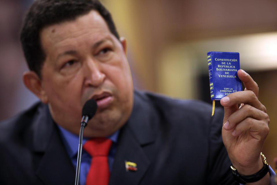 Venezuela's President Hugo Chavez holds up a miniature copy of Venezuela's constitution during a press conference at the Miraflores palace in Caracas, Venezuela, Tuesday, Oct. 9, 2012. The 58-year-old former military officer Chavez won his fourth consecutive presidential bid Sunday and shows no signs of ballot fatigue. (AP Photo/Rodrigo Abd)