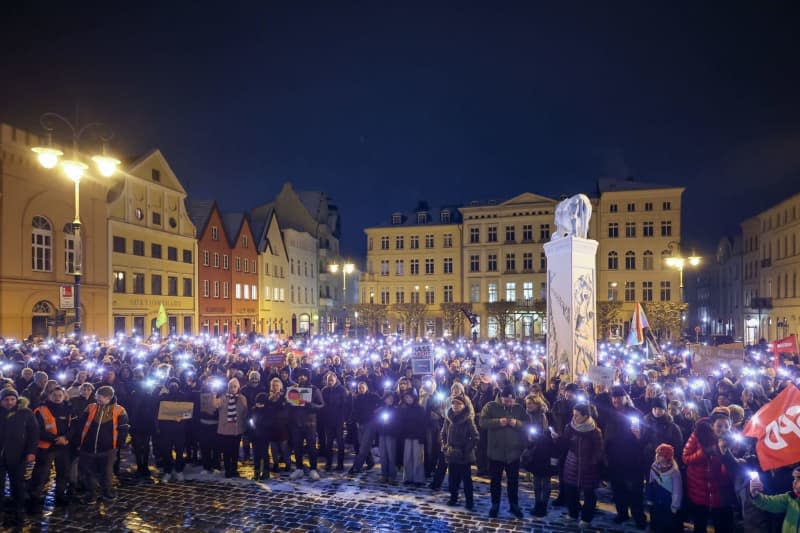 Protesters demonstrate against the AfD and right-wing extremism with placards and chants on the market square in Schwerin. Ulrich Perrey/dpa