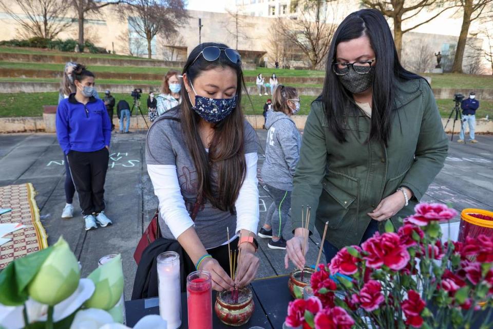 Kim Kean, left, and Rachel McDaniel light incense at an Asian Solidarity Candlelight Vigil in Charlotte, N.C., on Sunday, March 21, 2021.