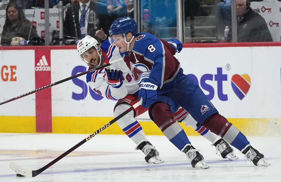 Colorado Avalanche defenseman Cale Makar, front, is defended by New York Rangers center Vincent Trocheck during the second period of an NHL hockey game Thursday, March 28, 2024, in Denver. (AP Photo/David Zalubowski)