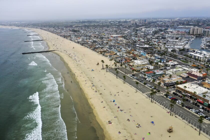 NEWPORT BEACH, CA -- TUESDAY, APRIL 28, 2020: An aerial view of beach-goers enjoying a partially-sunny, warm day on the beach near the pier in Newport Beach, CA, on April 28, 2020. Newport Beach City Council members are holding a special meeting to discuss closing the city's beaches for the next few weekends following Gov. Gavin Newsom's criticism of the large crowds and lack of social distancing.(Allen J. Schaben / Los Angeles Times)