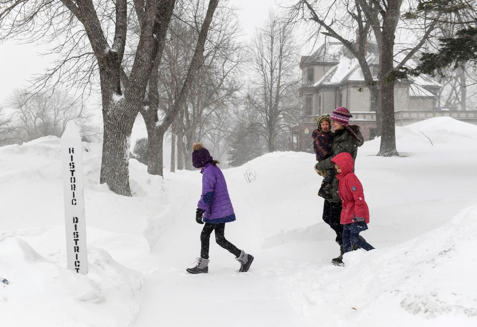 A family walks through blowing snow as weather conditions worsen on Wednesday, Feb. 22, 2023, in Sioux Falls, South Dakota (Erin Woodiel /The Argus Leader via AP) (AP)