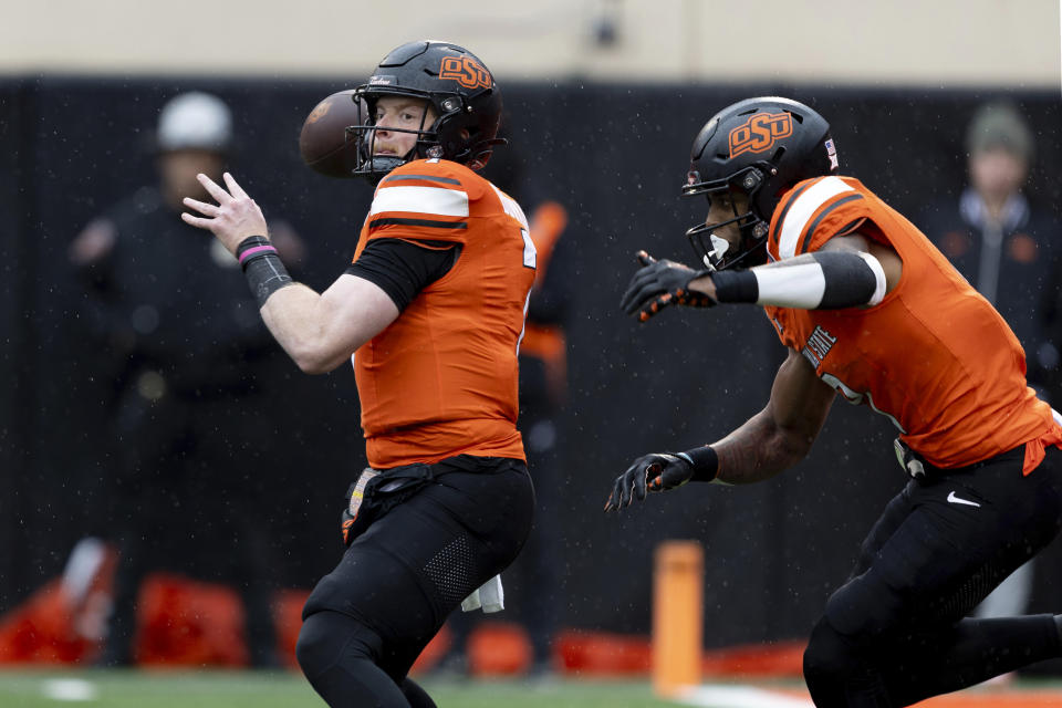 Oklahoma State quarterback Alan Bowman (7) throws a pass in front of running back Ollie Gordon II (0) in the first half of an NCAA college football game against BYU Saturday, Nov. 25, 2023, in Stillwater, Okla. (AP Photo/Mitch Alcala)