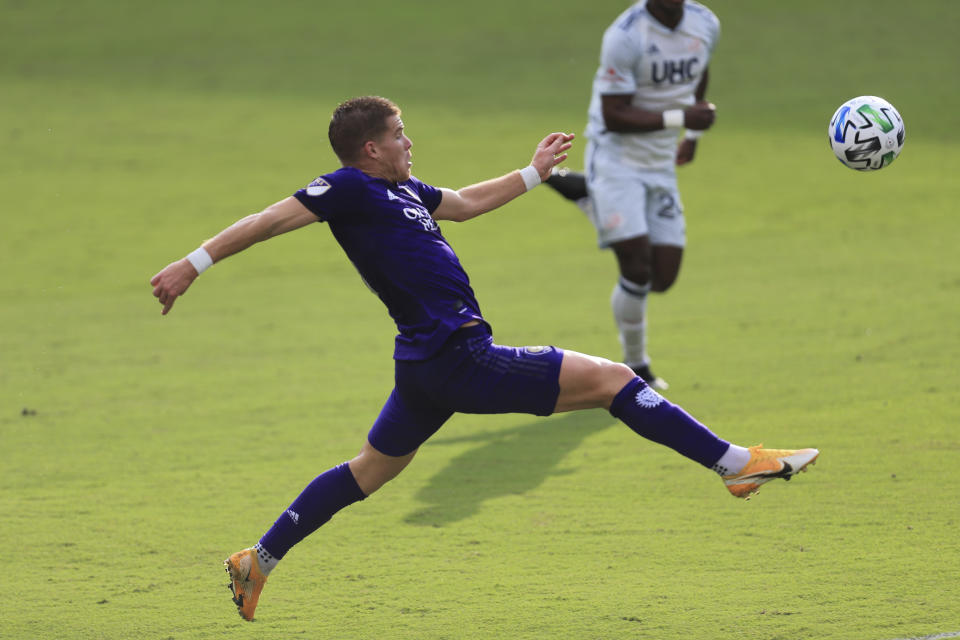 Orlando City forward Chris Mueller (9) jumps to control the ball against the New England Revolution during the first half of an MLS playoff soccer match, Sunday, Nov. 29, 2020, in Orlando, Fla. (AP Photo/Matt Stamey)