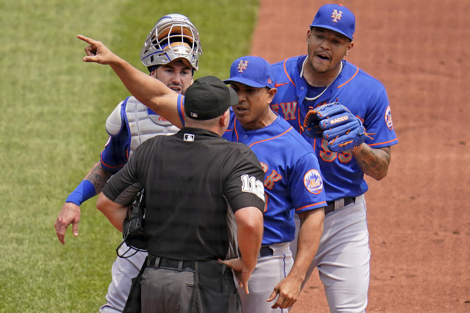 New York Mets manager Luis Rojas, center, makes his point to umpire Jeremy Riggs (112) with catcher Tomas Nido, left rear, and starting pitcher Taijuan Walker, right rear, looking on during the first inning of a baseball game against the Pittsburgh Pirates in Pittsburgh, Sunday, July 18, 2021. Rojas was ejected from the game. (AP Photo/Gene J. Puskar)
