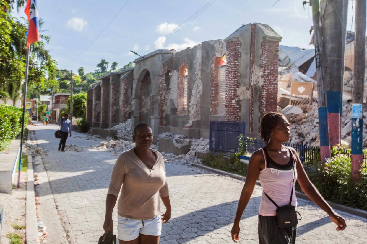  People walk by the collapsed Notre-Dame du Perpetuelle Secour church after a 7.2-magnitude earthquake struck Haiti on Saturday. (Getty Images)