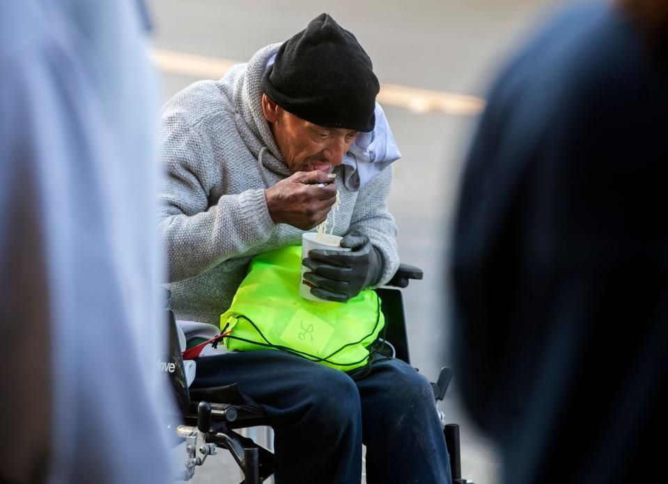 Danny Salazar has a ht cup of instant soup at a care package give away organized by Stockton resident Christine Vega on Lincoln Street near Weber Avenue in downtown Stockton on Dec. 9, 2023.