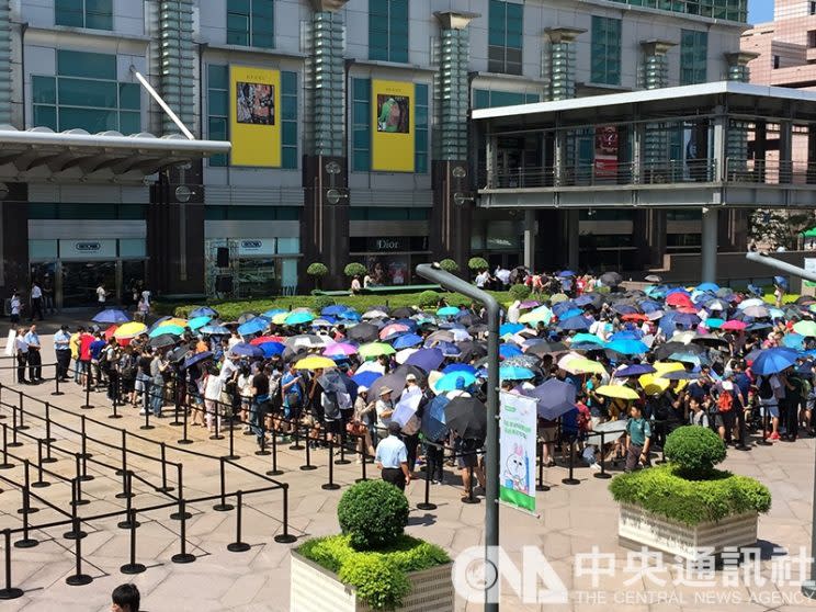 全台第一家Apple直營店於1日上午11時開幕，果粉無懼超過30度的高溫，在台北101大樓外廣場紛紛撐傘排隊。(中央社)