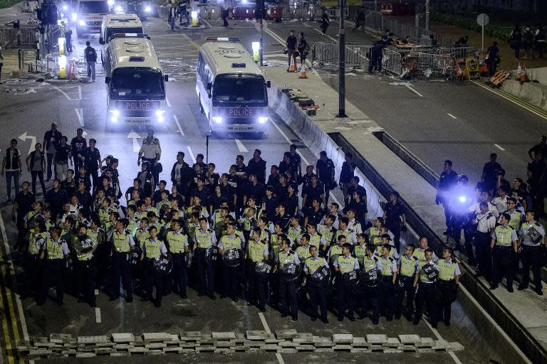 Police forces march toward protesters outside central government offices in Hong Kong on October 14, 2014