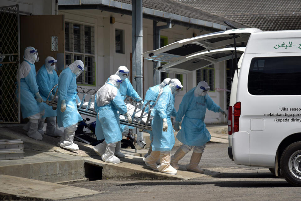 Health personnel transport the remains of a Covid-19 patient for burial at the Labuan Nucleus Hospital June 7, 2021. — Bernama pic