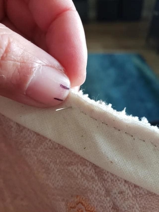 A person sewing with two marks on their thumbnail to create a straight and consistent stitching line