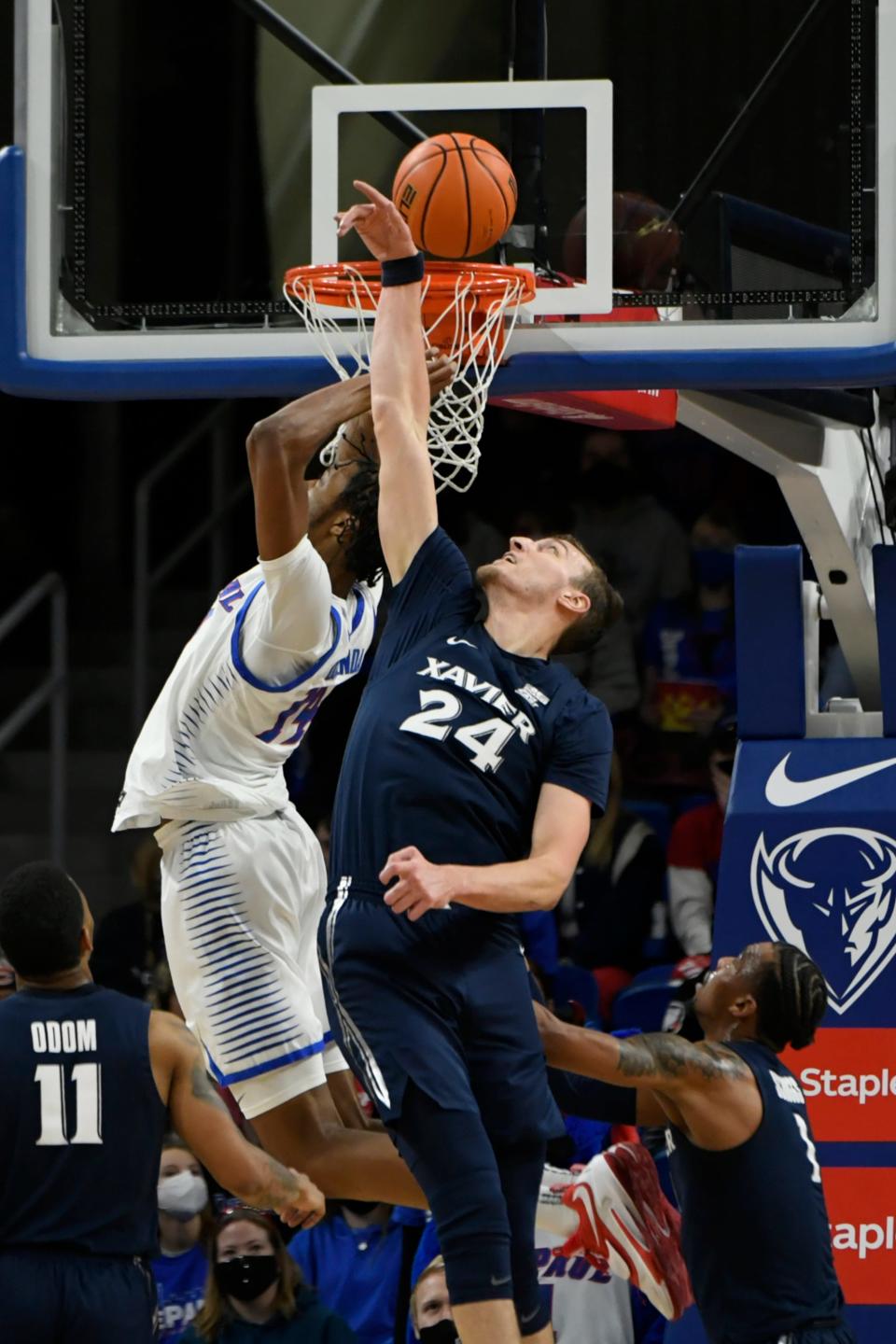 Xavier's Jack Nunge (24) battles DePaul's Nick Ongenda (14) for a rebound during the second half of an NCAA college basketball game Wednesday, Jan. 19, 2022, in Chicago. Xavier won 68-67. (AP Photo/Paul Beaty)