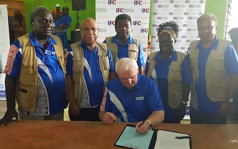 Bougainville Referendum Commission Chairman Bertie Ahern (C) signs the referendum announcement - but some experts have sounded a note of caution about the path ahead - Credit: Llane Munau/AFP