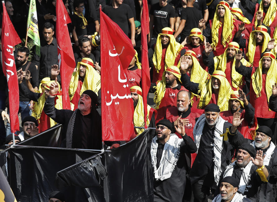 FILE - In this Sept. 10, 2019, file photo, Lebanese Shiite supporters of the Iranian-backed Hezbollah group raise their fists and chant slogans during Ashoura, the Shiite Muslim commemoration marking the death of Hussein, the grandson of the Prophet Muhammad, in present-day Iraq in the seventh century, Tuesday, Sept. 10, 2019, in Beirut, Lebanon. Shiites mark Ashoura, the 10th day of the month of Muharram, to commemorate the Battle of Karbala when Imam Hussein, a grandson of Prophet Muhammad, was killed. (AP Photo/Hussein Malla, File)