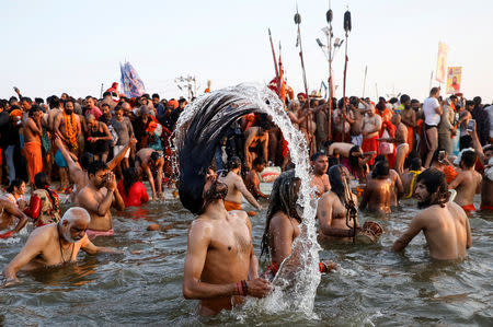 FILE PHOTO: Naga Sadhus or Hindu holy men take a dip during the first "Shahi Snan" (grand bath) at "Kumbh Mela" or the Pitcher Festival, in Prayagraj, previously known as Allahabad, India, January 15, 2019. REUTERS/Danish Siddiqui/File Photo