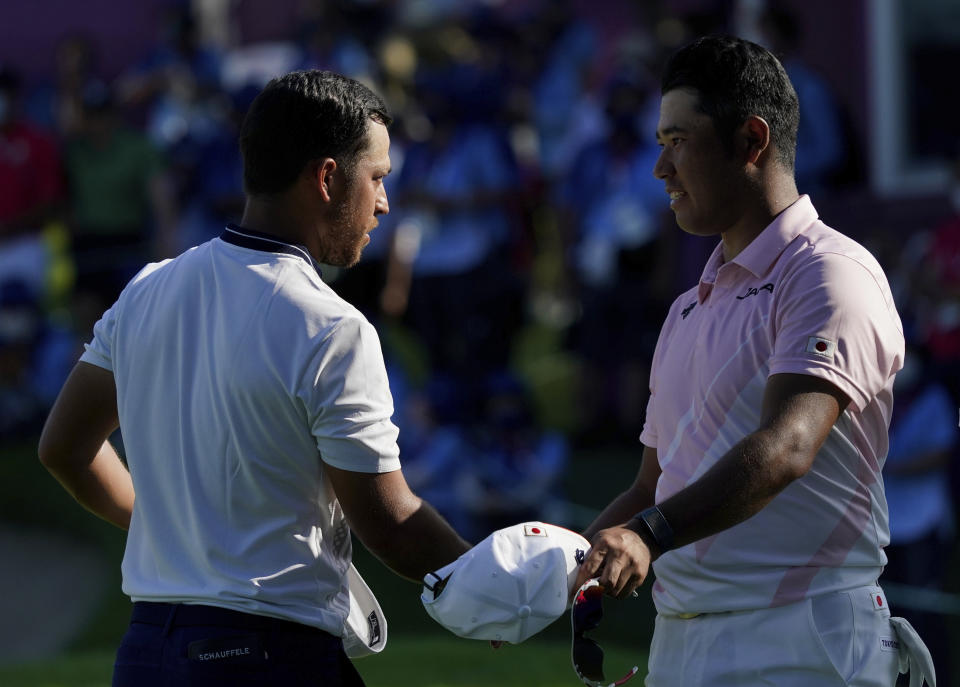 Xander Schauffele of United States, left, shakes hand with Hideki Matsuyama of Japan at the end of the third round of the men's golf event at the 2020 Summer Olympics on Saturday, July 31, 2021, in Kawagoe, Japan. (AP Photo/Matt York)