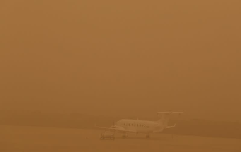 A plane is seen parked on a tarmac during a sandstorm blown over from North Africa known as "calima" at Las Palmas Airport