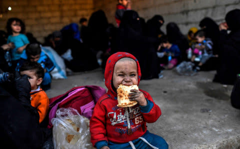 Syrian women and children gather on the western front after fleeing the centre of Raqqa on October 12, 2017 - Credit: AFP