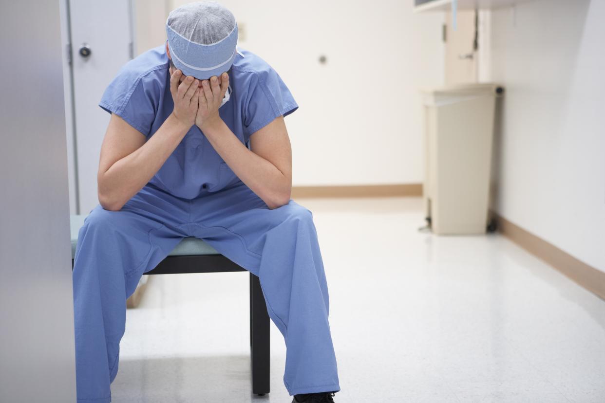 Doctor sitting with head in hands