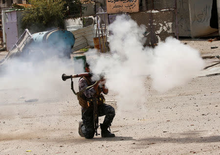 FILE PHOTO - Federal police members fire a rocket at Islamic State fighters' positions during a battle at Jada district in western Mosul. REUTERS/Youssef Boudlal