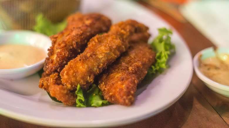 Crunchy chicken tenders on plate