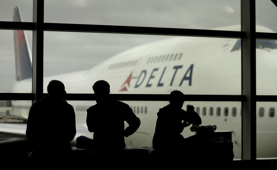 Travelers on Delta Airlines waits for flights Monday, Oct. 29, 2012, in Detroit. Dozens of departing flights have been canceled at Detroit Metropolitan Wayne County Airport as a looming superstorm locks down flights to the East Coast. Hurricane Sandy continued on its path Monday, as the storm forced the shutdown of mass transit, schools and financial markets, sending coastal residents fleeing, and threatening a dangerous mix of high winds and soaking rain. (AP Photo/Charlie Riedel)