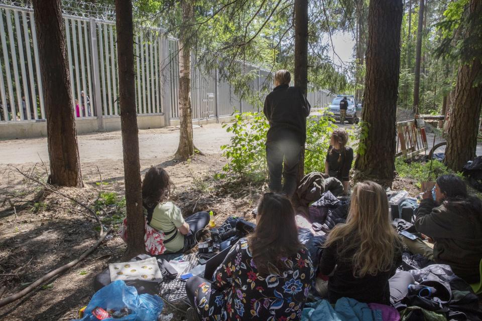 Human rights activists monitoring and supporting a group of some 30 migrants in Bialowieza, Poland, on Sunday, 28 May 2023 who have been stuck at a wall that Poland built last year on its border with Belarus to stop massive migrant pressure. The group has remained stuck at the spot for three days, according to human rights activists. (AP Photo/Agnieszka Sadowska)