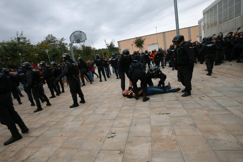 <p>Spanish Civil Guard officers remove a man outside a polling station for the banned independence referendum in Sant Julia de Ramis, Spain on Oct.1, 2017. (Photo: Albert Gea/Reuters) </p>