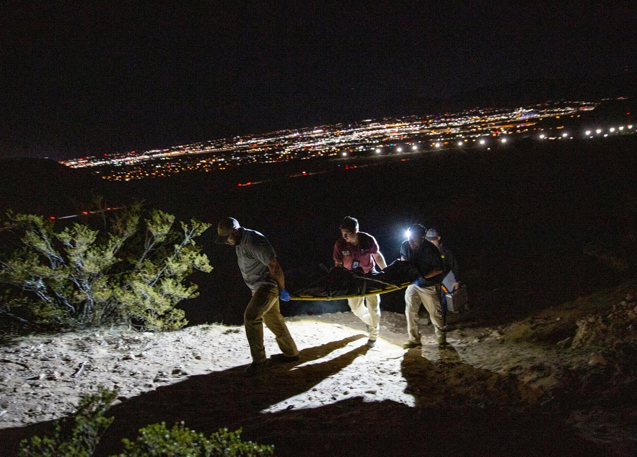 The body of a Guatemalan migrant is recovered by Juárez forensic officials after she was found dead in a canyon just south of the international boundary. In the background, the lights of Sunland Park, New Mexico, can be seen on Nov. 7, 2023.