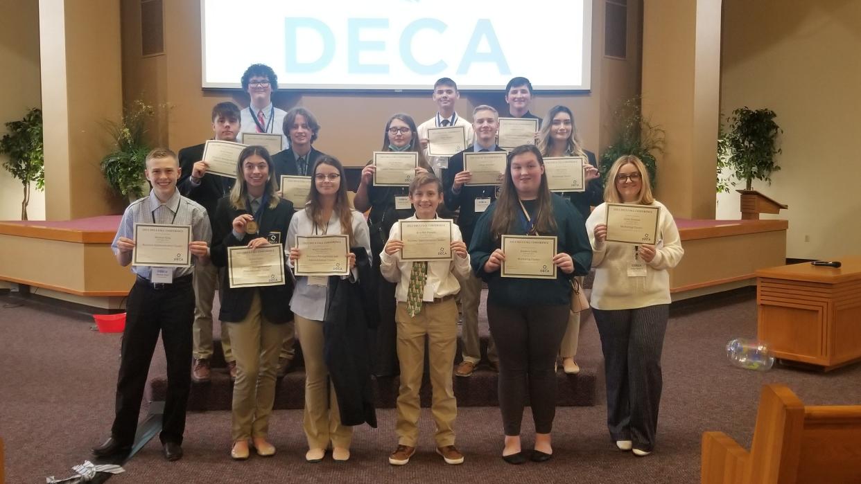 Alma students presenting their awards from the 
DECA conference in Fort Smith