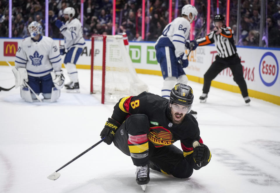 Vancouver Canucks' Conor Garland (8) celebrates his second goal against Toronto Maple Leafs goalie Martin Jones, back left, during the second period of an NHL hockey game in Vancouver, British Columbia, Saturday, Jan. 20, 2024. (Darryl Dyck/The Canadian Press via AP)