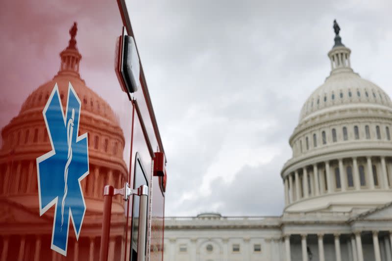 The U.S. Capitol Building is reflected against an ambulance along the East Front on Capitol Hill in Washington