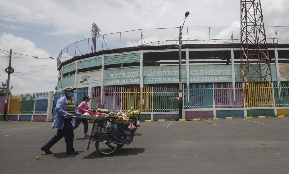 Street vendors push their fruit for sale outside Roberto Clemente baseball stadium in Masaya, Nicaragua, Thursday, May 28, 2020. As the new coronavirus spread and economies shut across Latin America, Nicaragua stayed open _ schools, stores, concert halls, and baseball stadiums, all operating uninterrupted on orders of a government that denied the gravity of the disease. (AP Photo/Alfredo Zuniga)