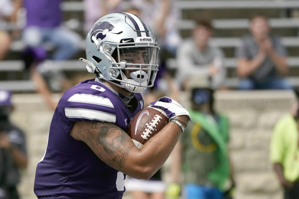 FILE - Kansas State tight end Briley Moore runs the ball during the first half of an NCAA college football game in Manhattan, Kan., in this Saturday, Sept. 12, 2020, file photo. The coronavirus pandemic scuttled the annual NFL scouting combine in Indianapolis, leaving prospects to show off for scouts, coaches and general managers at their college pro day instead. While players lamented the lost opportunity to gather in Indy to be poked, prodded, timed and tested — and to square off against their peers — an invitation was still a golden ticket. (AP Photo/Charlie Riedel, File)