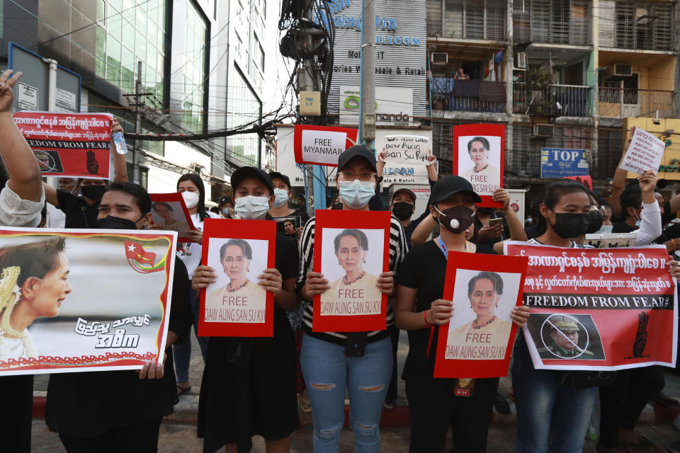 Protesters hold posters with an image of deposed Myanmar leader Aung San Suu Kyi as they march in Yangon, Myanmar on Monday, Feb. 8, 2021. Tension in the confrontations between the authorities and demonstrators against last week's coup in Myanmar boiled over Monday, as police fired a water cannon at peaceful protesters in the capital Naypyitaw. (AP Photo)