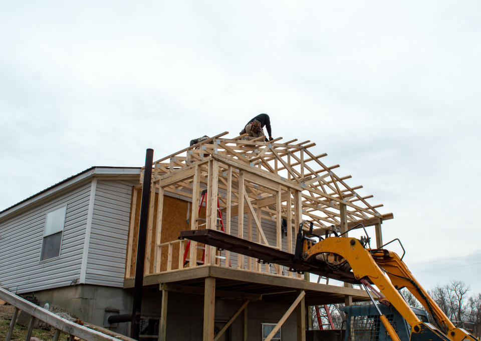 property Unidentified carpenters work on the new roof, aided by some heavy equipment. Construction work is progressing nicely