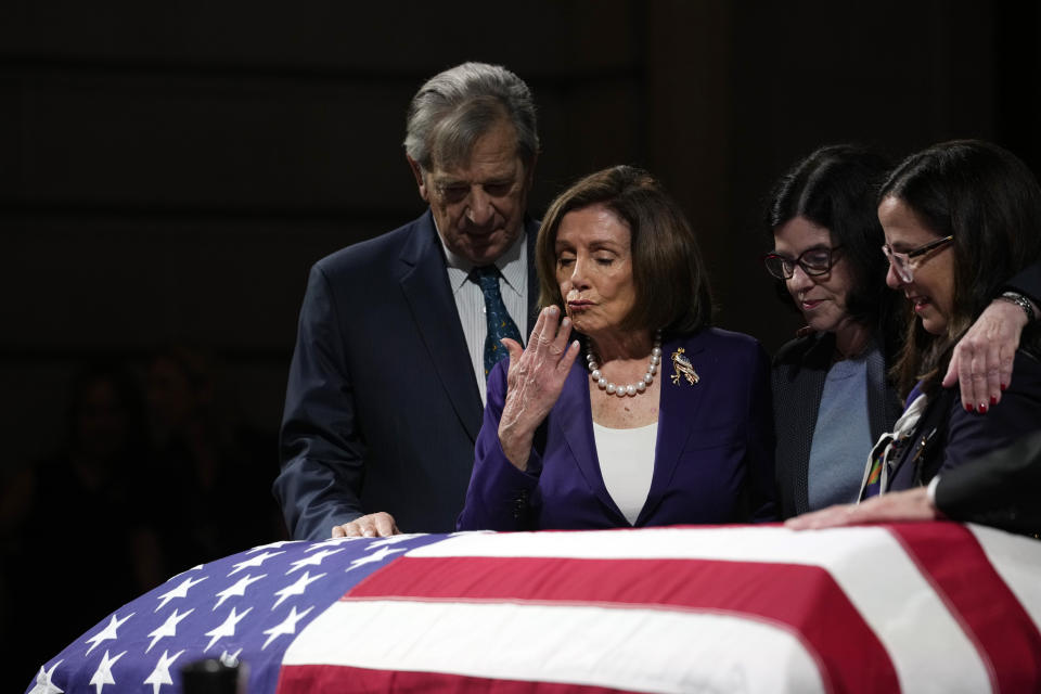 Rep. Nancy Pelosi, surrounded by her family, blows a kiss at Feinstein’s casket, which is draped with an American flag.