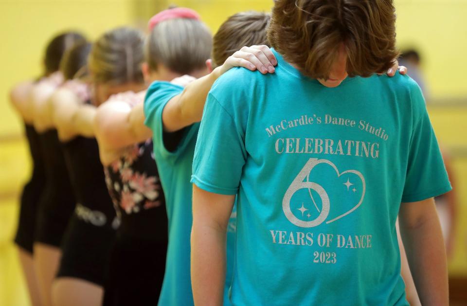 Students wear shirts celebrating the 60th anniversary of McCardle’s Dance Studio during a rehearsal Monday for their June 3 dance review at Cuyahoga Falls High School.