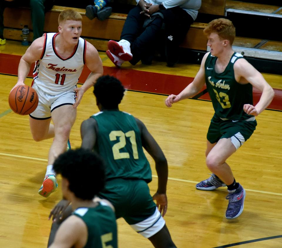 Logan Frank looks to pass for Monroe pressured by Jackson Keefer and Macari Moore of Ann Arbor Huron Tuesday, Monroe fell 58-27.