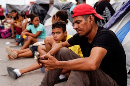 Asylum seekers pass their time in an encampment near the Gateway International Bridge in Matamoros, Mexico