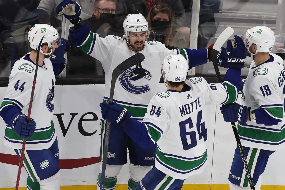 Vancouver Canucks' Conor Garland (8) celebrates his goal with teammates Kyle Burroughs (44), Tyler Motte (64) and Jason Dickinson (18) during the second period of an NHL hockey game against the Boston Bruins, Sunday, Nov. 28, 2021, in Boston. (AP Photo/Michael Dwyer)