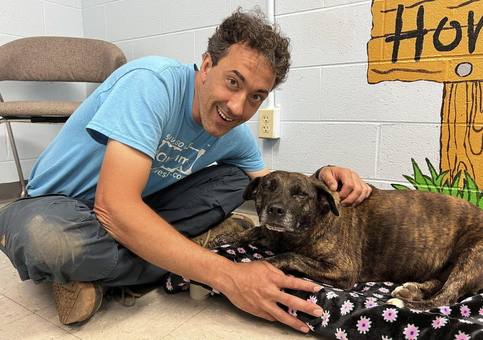 In this image provided by Skylar Sojka, shelter manager at Giles County, Va., Animal Shelter, Jesse Rochette poses with Sparsy at the shelter in Pearisburg, Va. A group of cavers, including Rochette, who were exploring in western Virginia over the weekend rescued the dog that the Giles County shelter is calling a “living miracle” after she was found 40 to 50 feet down in a cave. (Skylar Sojka/Giles County Animal Shelter via AP)