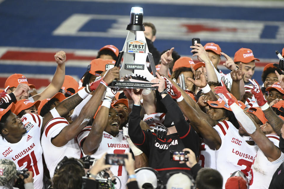 Louisiana-Lafayette linebacker Ferrod Gardner (7), coach Billy Napier and others hold up the trophy after a 31-24 win over UTSA in the First Responder Bowl NCAA college football game in Dallas, Saturday, Dec. 26, 2020. (AP Photo/Matt Strasen)