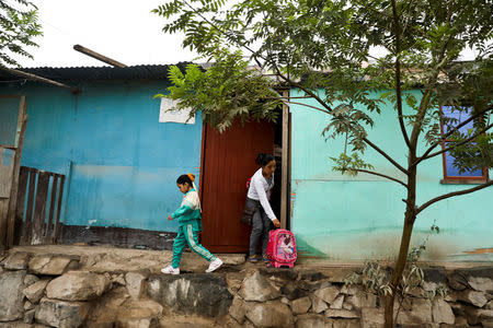 Sandra Saccaco, a resident of Nueva Union shantytown who plays volleyball at a makeshift soccer field, and her daughter Cristel Acevedo leave home to go to school in Villa Maria del Triunfo district of Lima, Peru, June 1, 2018. REUTERS/Mariana Bazo