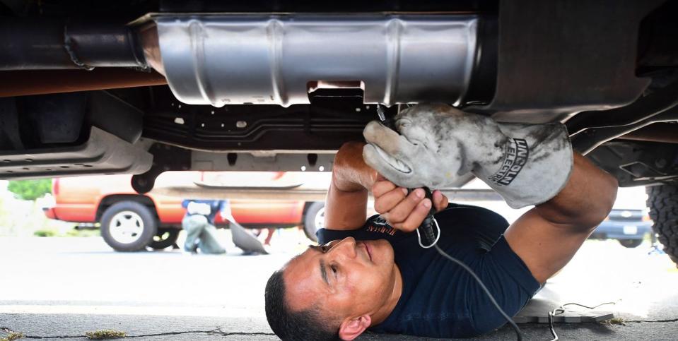 deputy jaime moran from the los angeles sheriffs department engraves the catalytic converter of a vehicle with a traceable number  on july 14, 2021, in city of industry, california   theft of catalytic converters across the us have soared over the course of the covid 19 pandemic, valuable to scrap metal dealers for the precious metals including rhodium, platinum and palladium photo by frederic j brown  afp photo by frederic j brownafp via getty images