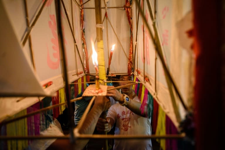 A participant looks into a large paper lantern after lighting a candle before the annual Tai Hang "fire dragon" event, one of the highlights of the city's mid-autumn festival, in Hong Kong