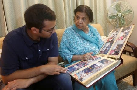 Rehana Khursheed Hashmi, 75, migrated from India with her family in 1960 and whose relatives, live in India, speaks with her grandson Zain Hashmi, 19 while looking family photo album at her residence in Karachi, Pakistan August 7, 2017. REUTERS/Akhtar Soomro